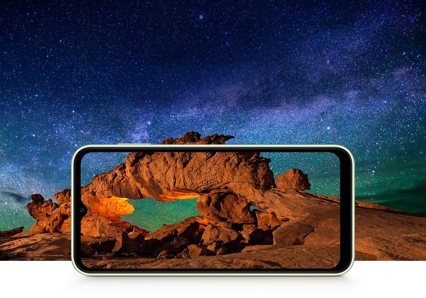 'L'immagine mostra maestose formazioni rocciose di colore arancio-marrone sotto un cielo stellato su un Galaxy A14 5G in modalità paesaggio. L'immagine si allarga oltre lo schermo del dispositivo, mettendo in evidenza l'esperienza immersiva prodotta dal display.