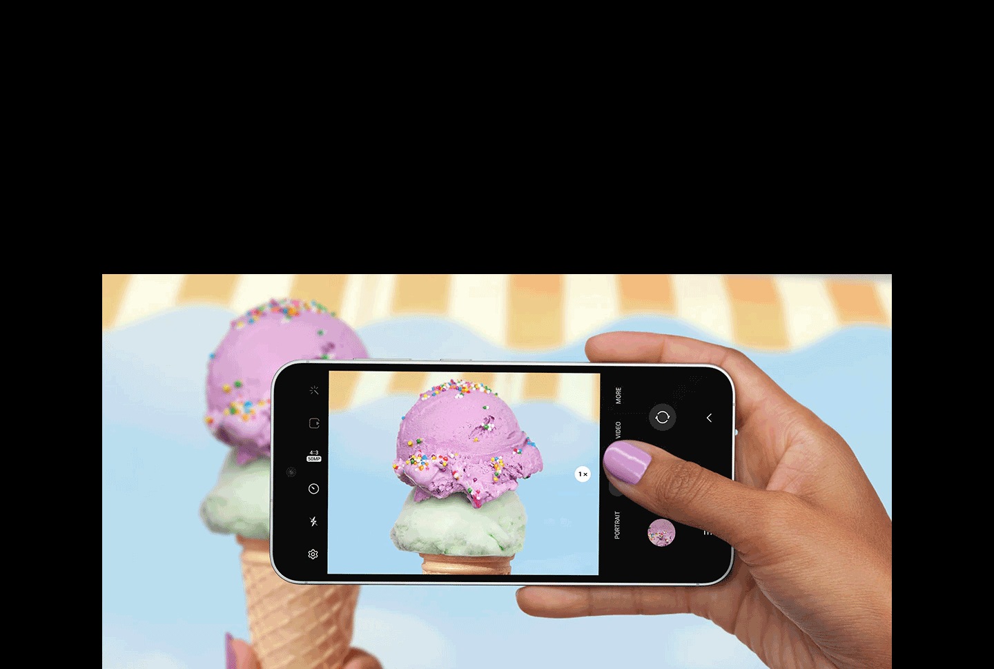Una mano scatta una foto con un dispositivo Samsung Galaxy S23 FE visto dal davanti, in orizzontale. Lo schermo in modalità immagine mostra l’immagine nitida e dettagliata in primo piano di una pallina di gelato cosparsa di zuccherini multicolori.
