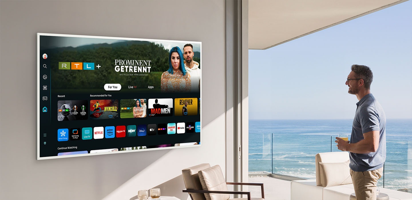 A man is looking at various entertainment options offered on Samsung Tizen OS on The Frame TV.
