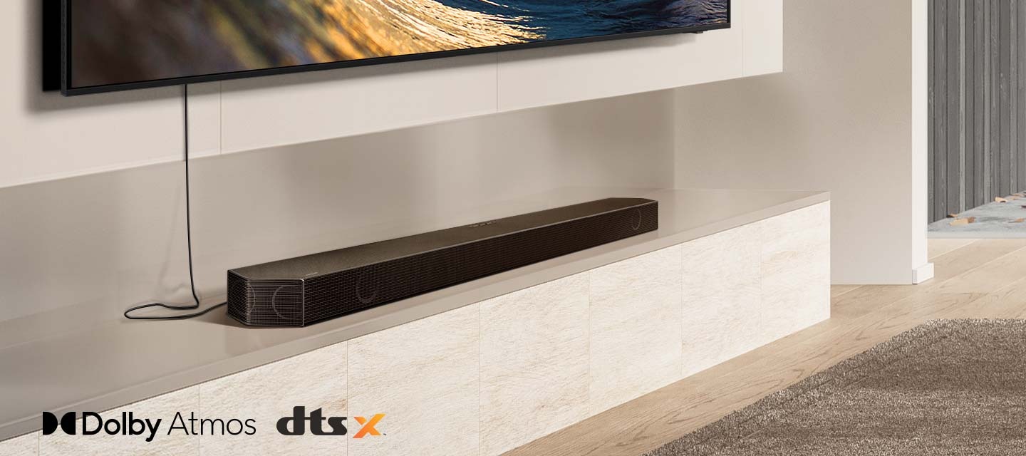 A close-up on a Soundbar sitting underneath a TV, along with the logos for Dolby Atmos and DTS:X. A Wi-Fi signal icon pops up near the Soundbar. The scene zooms out to reveal an entire living room, with rear speakers set up in the back. Sound waves emanate from the Soundbar and rear speakers, reflecting off the ceiling and traveling around the room.