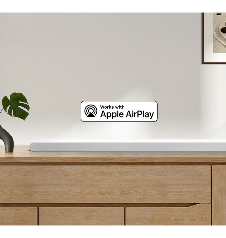 A Samsung Soundbar sits on top of a cabinet, accompanied by a logo for Works with Apple AirPlay.