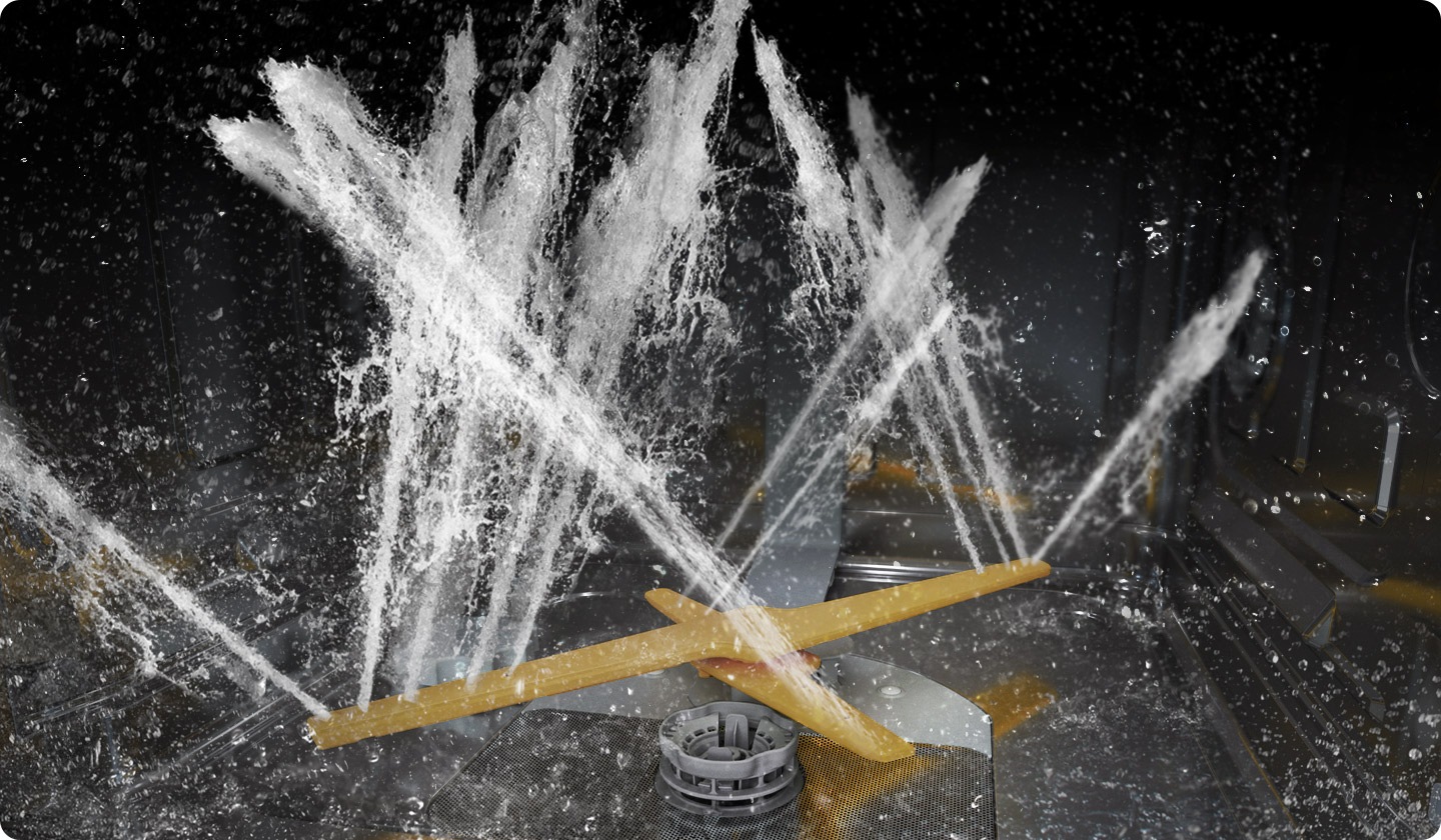 A WaterJet Clean™ rendszer forgó kettős mosókarjait mutatja, amelyek erőteljes vízsugarakat permeteznek több irányba.