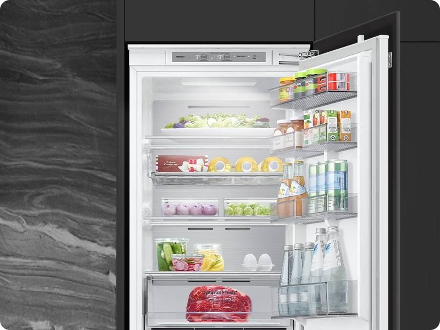 The refrigerator's lighting adjusts to match the surrounding environment, revealing its interior.