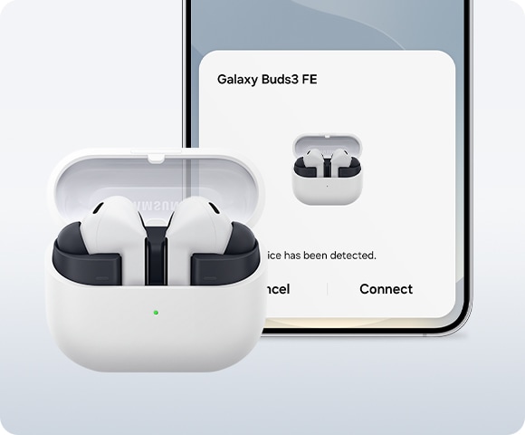 Gray Galaxy Buds3 FE with the charging case open, in front of a Samsung Galaxy S25 displaying the pairing pop-up screen.