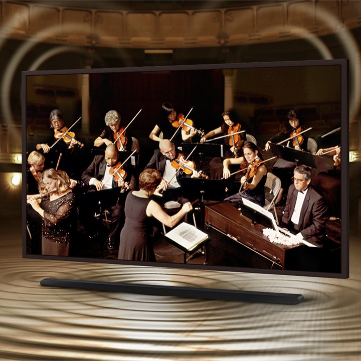  The Frame mostra un'orchestra sul suo schermo. La soundbar si trova sotto The Frame con increspature sonore che ne escono per mostrare che il suono degli altoparlanti su The Frame e Soundbar sono perfettamente sincronizzati.