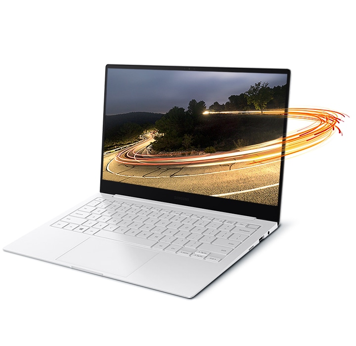 Light swirls encircle a laptop screen, encompassing a photo of a mountain road displayed on the screen of Galaxy Book Pro.