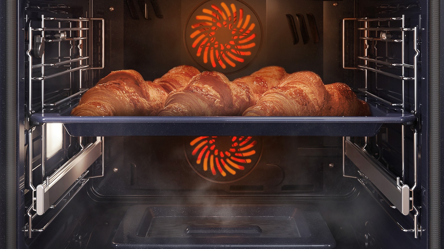  Mostra una teglia di croissant all'interno del forno in cottura con il sistema a convezione, mentre è avvolta dal vapore che sale da un'apposita teglia posta sul fondo del forno.