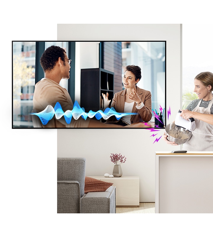 A woman is cooking while watching TV. Despite the noise coming from the mixer, the Active Voice Amplifier technology makes it easy to hear TV conversations.