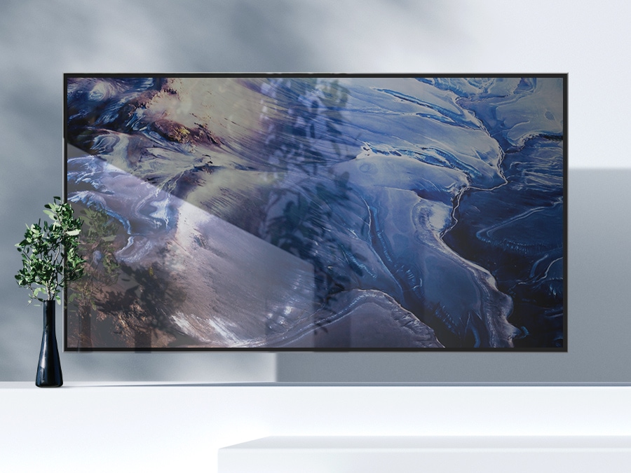 A QLED TV shows matte wave-like blue graphics on the screen with a lot of light reflections.