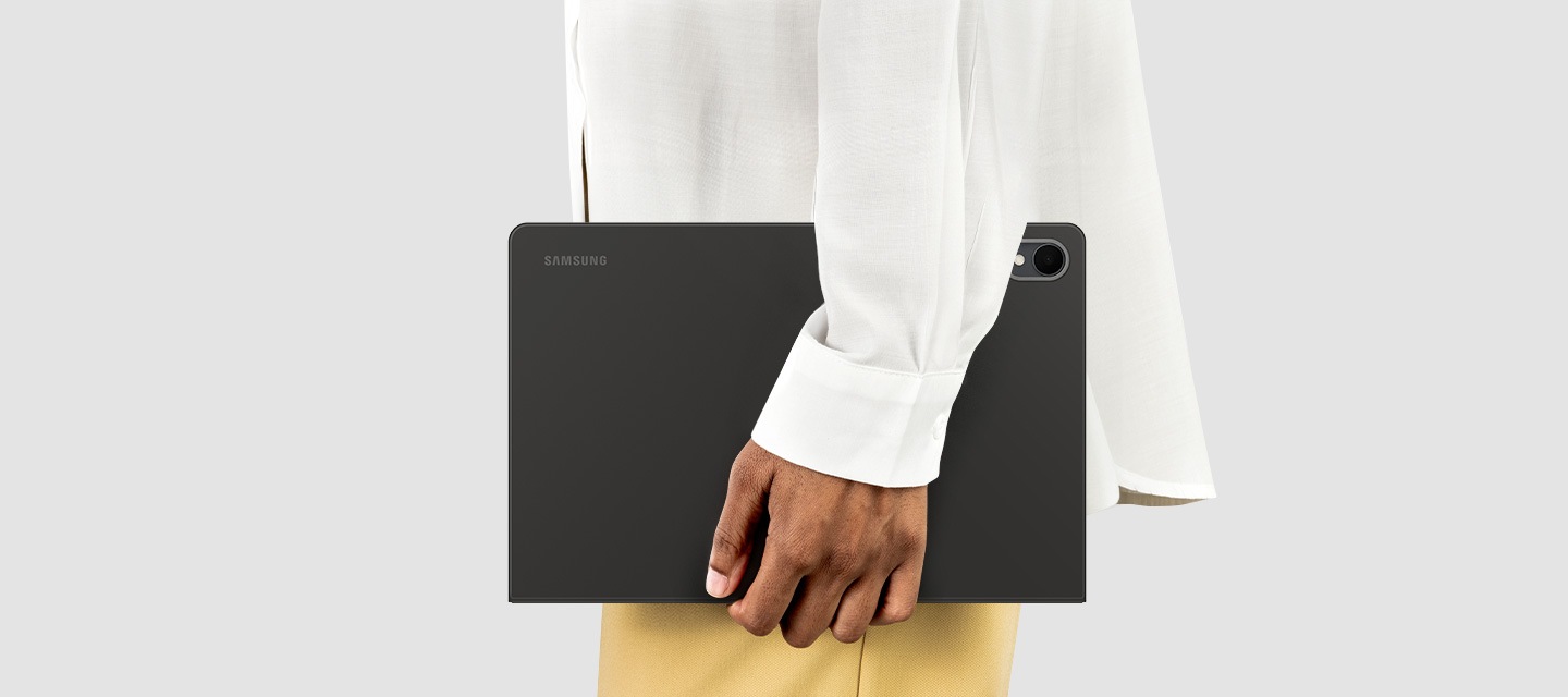 Side view of a person holding Galaxy Tab S11 with Book Cover on, showing its slim profile and lightweight form that is easy to carry for everyday use on the go.