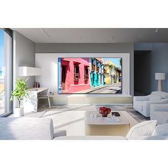 A 98 inch QLED TV hangs on the wall in a living room, displaying vibrant houses.