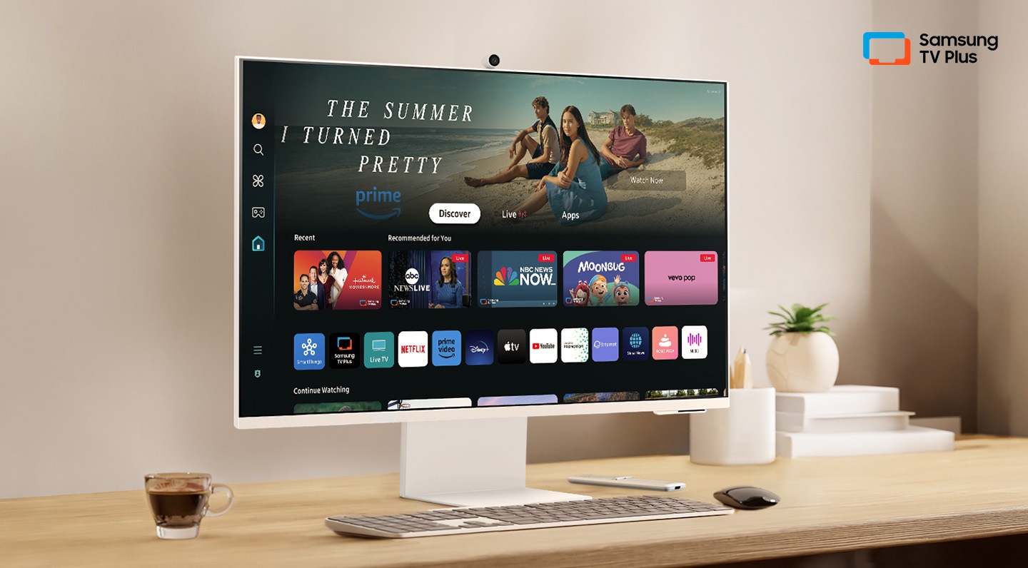 Hay un monitor en un escritorio y la interfaz del usuario local se muestra con aplicaciones OTT. En la parte superior derecha, hay un logotipo de Samsung TV Plus. Hay un monitor en un escritorio y su interfaz de usuario doméstica se muestra con aplicaciones OTT. En la parte superior derecha, hay un logotipo de Samsung TV Plus.