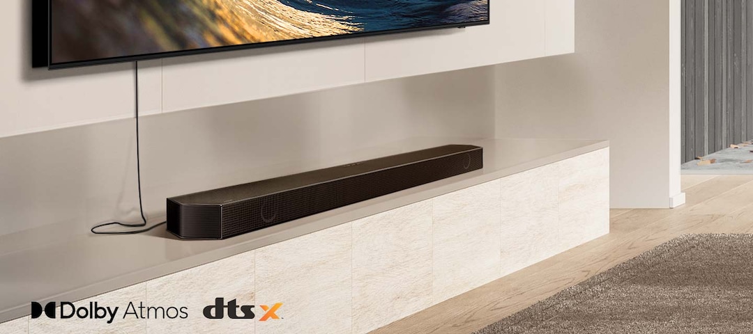 Barra de sonido bajo un TV con ondas Dolby Atmos llenando el living