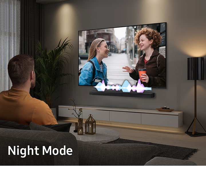 Una persona mira TV de noche con la barra en Modo Nocturno