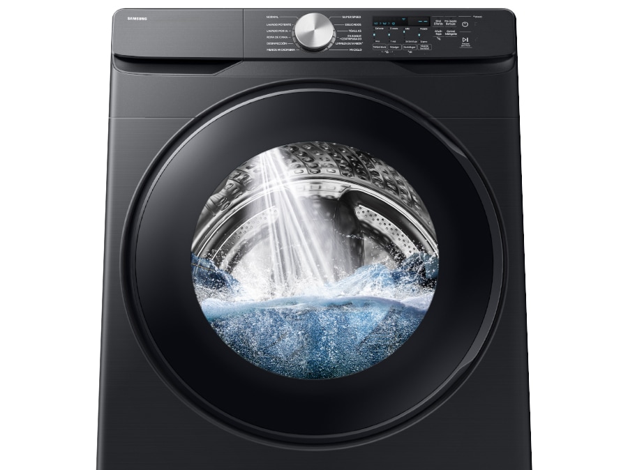 A powerful jet of water is being sprayed into the drum of a washing machine.