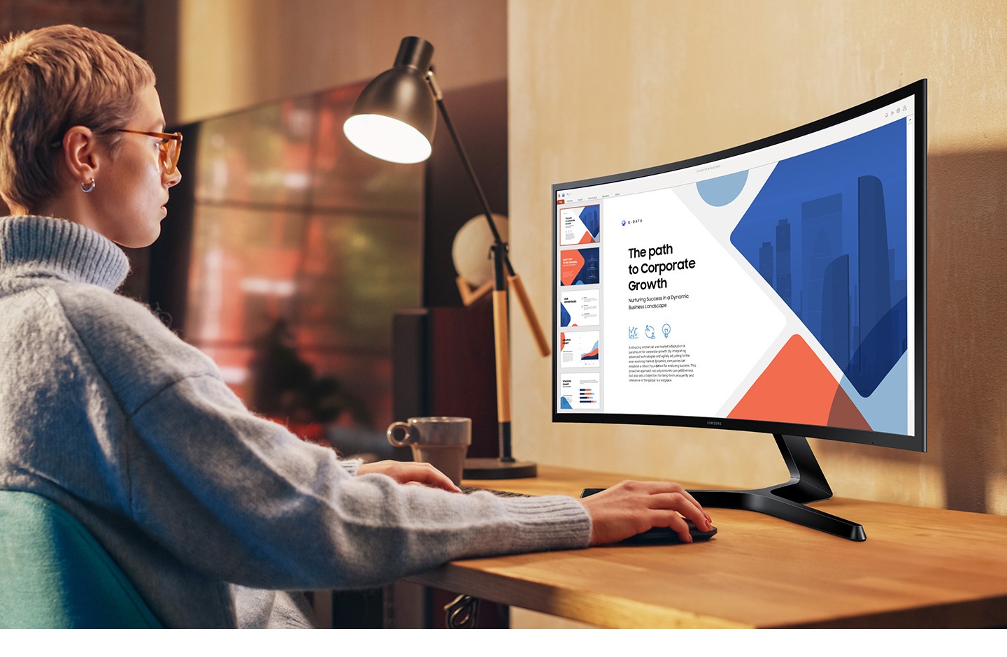 Una mujer está sentada frente a un escritorio utilizando un monitor.