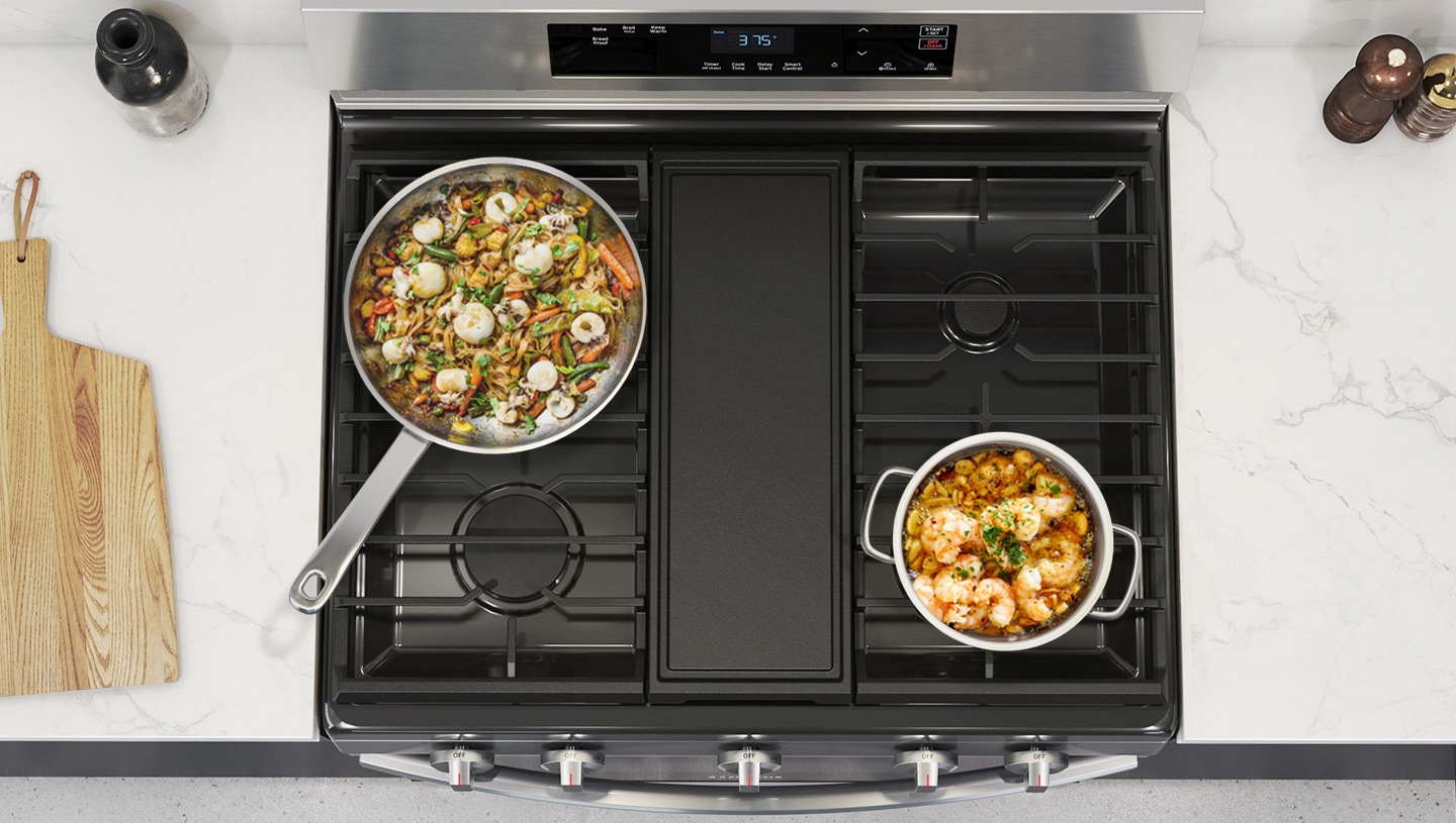 Looks down on the cooktop to show how the Edge to Edge Grates provide a wider cooking area to hold many different pans.