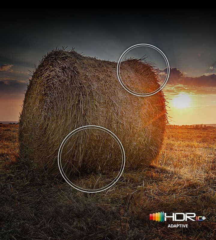 The sun is setting over a wide field with emphasis on a large hay stack. The scene after applying HDR 10+ ADAPTIVE/GAMING technology is much brighter and crisper than the SDR version.