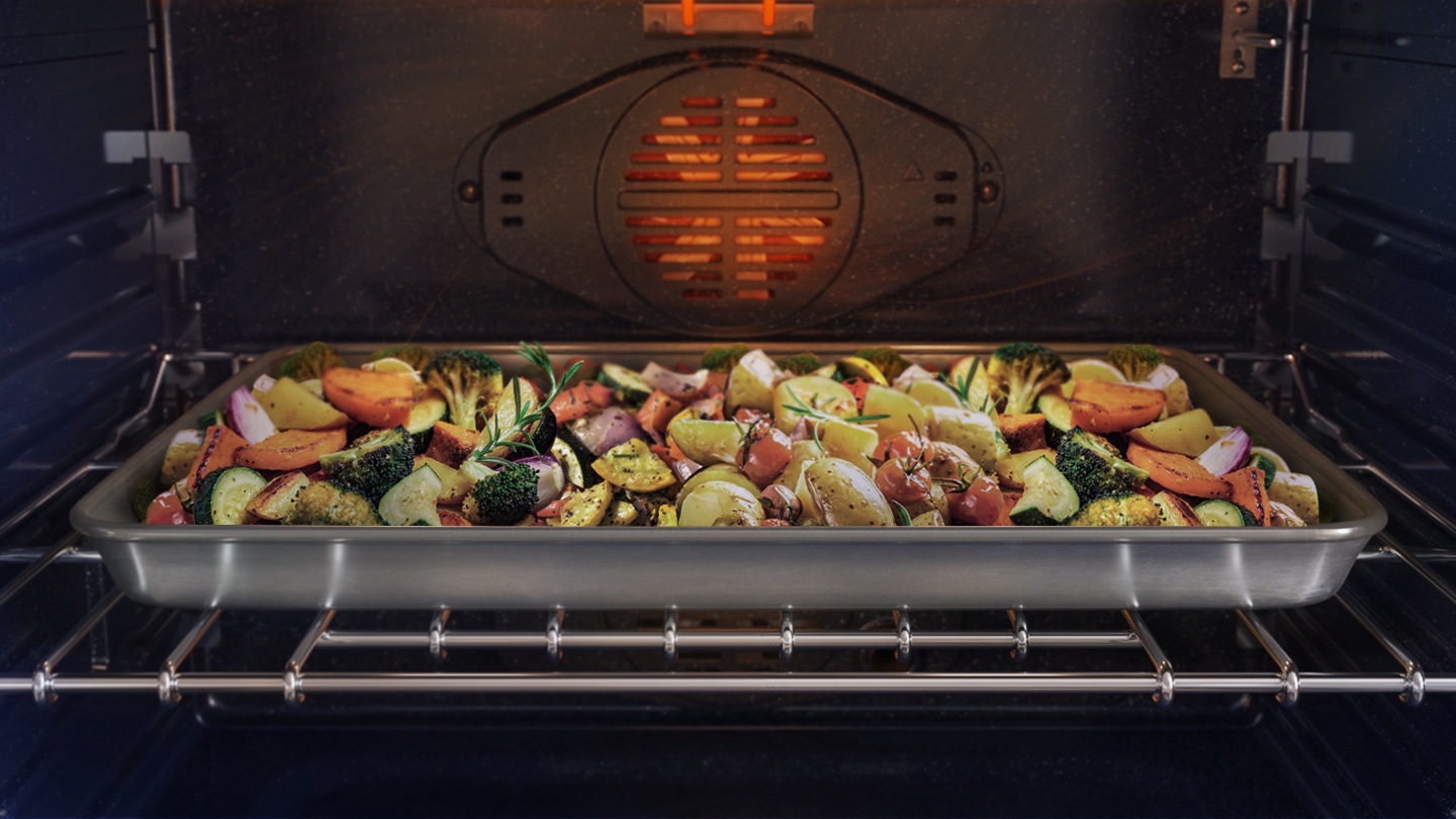 It shows various vegetables being cooked inside the oven.