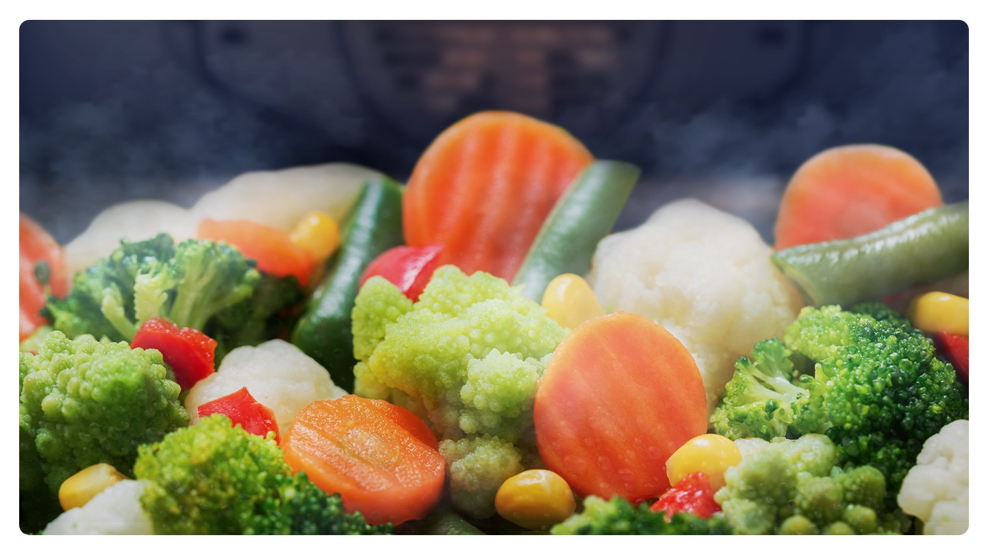 It shows vegetables inside the oven with steam coming out.