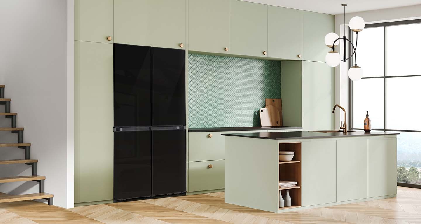 There is a french door Bespoke refrigerator in a sunlit contemporary kitchen with green cabinetry and a kitchen island.
