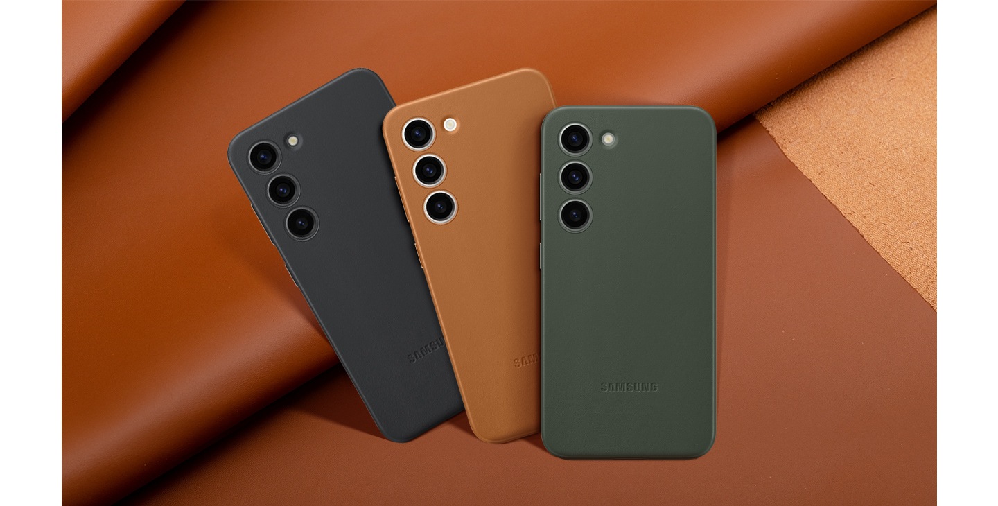 Back view of different color versions of the leather case lined up and overlapping in front of one another against a leather backdrop.