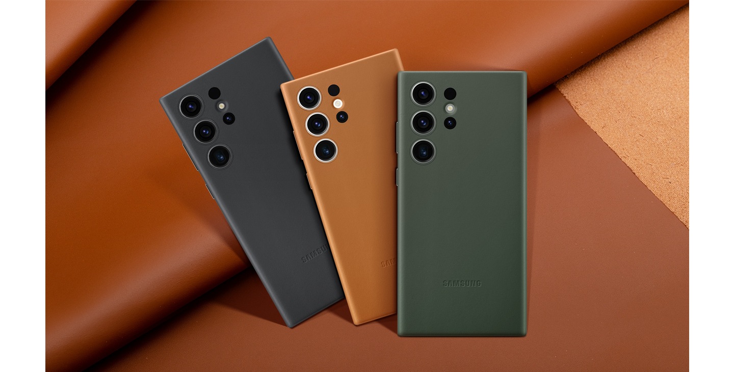 Back view of different color versions of the leather case lined up and overlapping in front of one another against a leather backdrop.