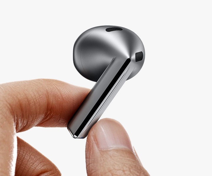 A finger swipes across the blade of a single, silver colored Galaxy Buds3 earbud.