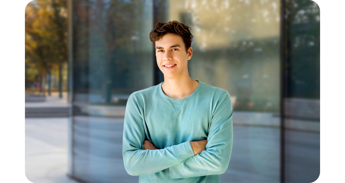 High quality portrait shot of a young man looking into camera lenses, while Reflective windows blurred out in the background