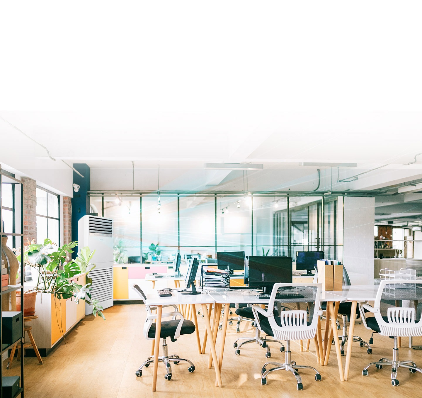 Shows air being dispersed by a floor-standing air conditioner across an office environment.