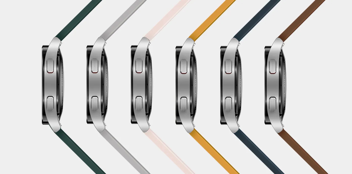 Six Watch4 devices are placed on its side, arranged sideways to show the band color of each device. From the left, the colors shown are Green, Silver, Pink, Mustard, Navy, and Camel.