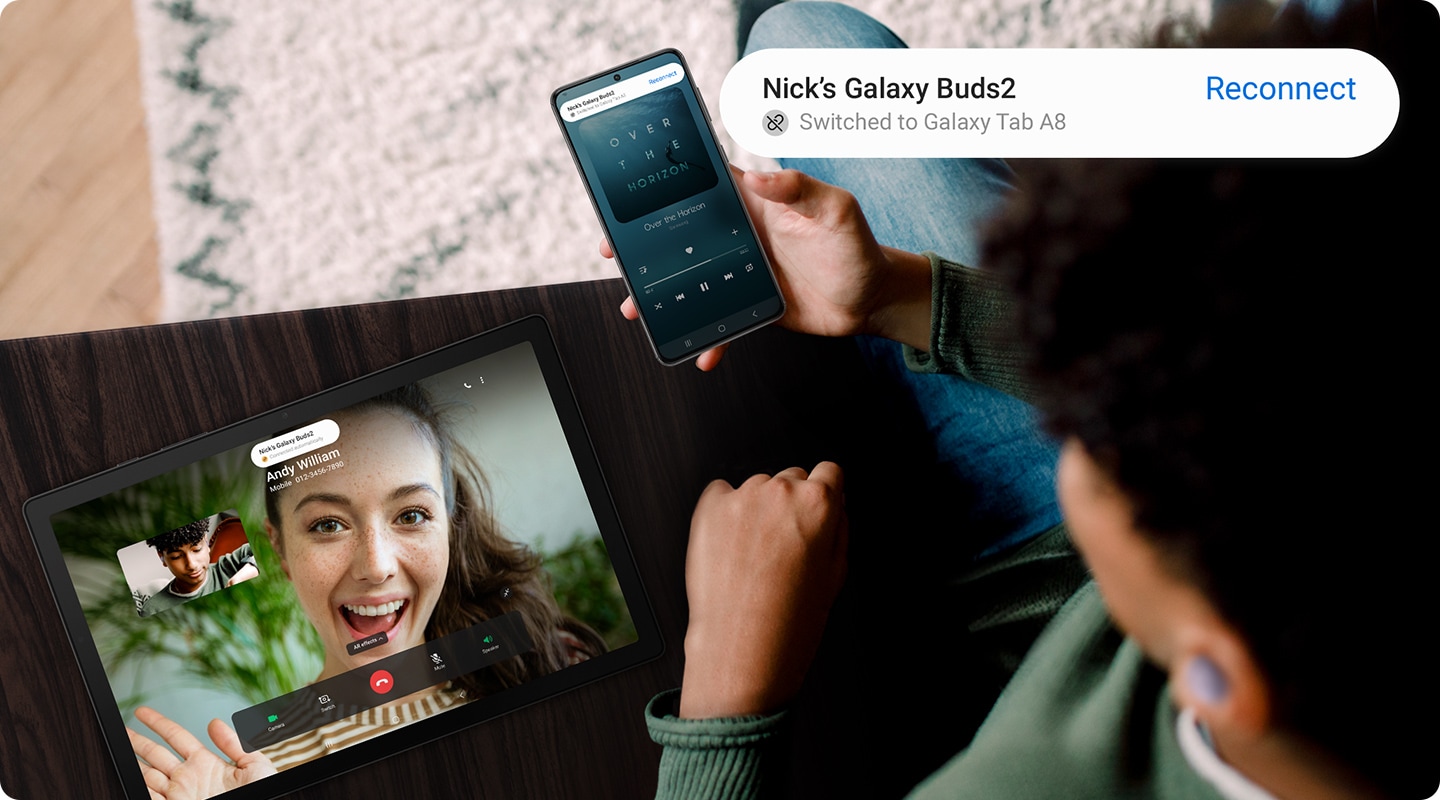 Мужчина со смартфоном Galaxy разговаривает по видеосвязи на Galaxy Tab A8. В уведомлении указано, что наушники Galaxy Buds, которые он носит, автоматически переключились на его планшет.