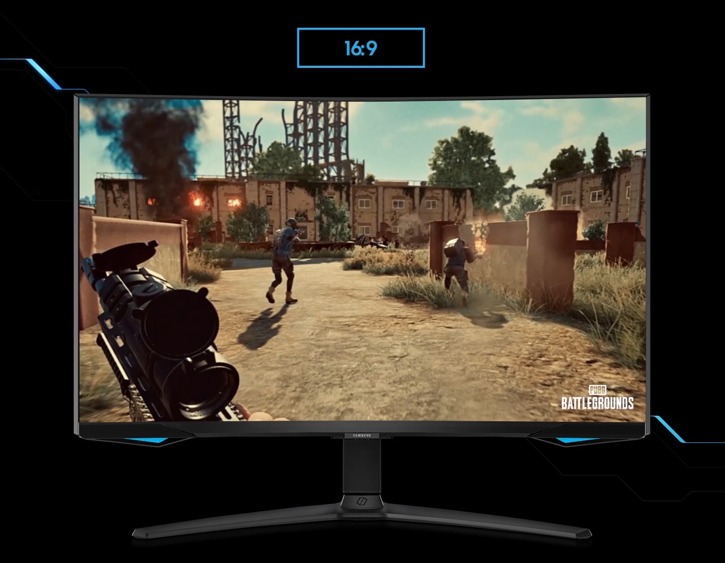 A monitor shows the perspective of a player within a first-person action game. As the screen is extended from 16:9 to 21:9 proportion, an enemy appears in the far left corner, revealed thanks to the monitor's wider perspective. The game title PUBG BATTLEGROUND is located in the lower right corner.