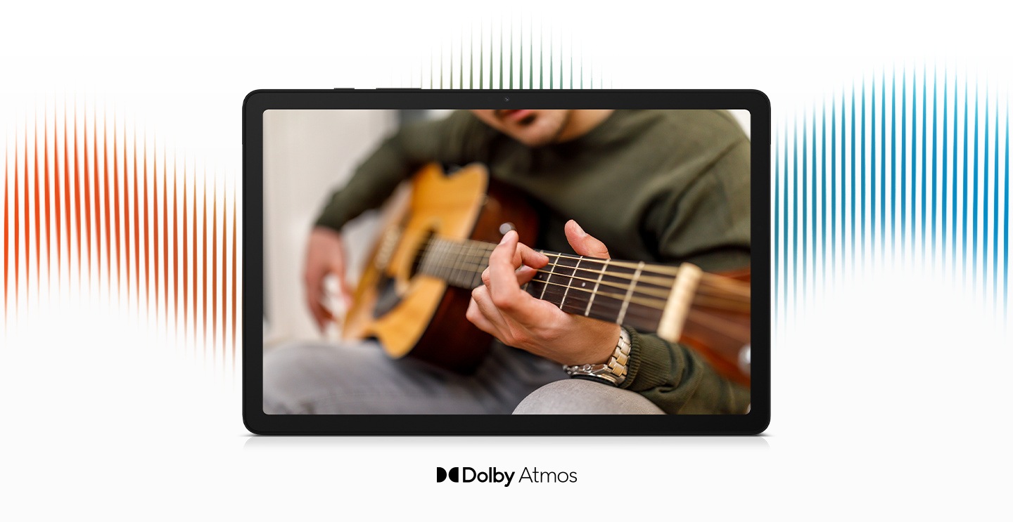 Galaxy Tab A9+ можно увидеть с человеком, играющим на гитаре.  За устройством находится графика, иллюстрирующая звуковые волны.  Под устройством находится фирменный знак Dolby Atmos.