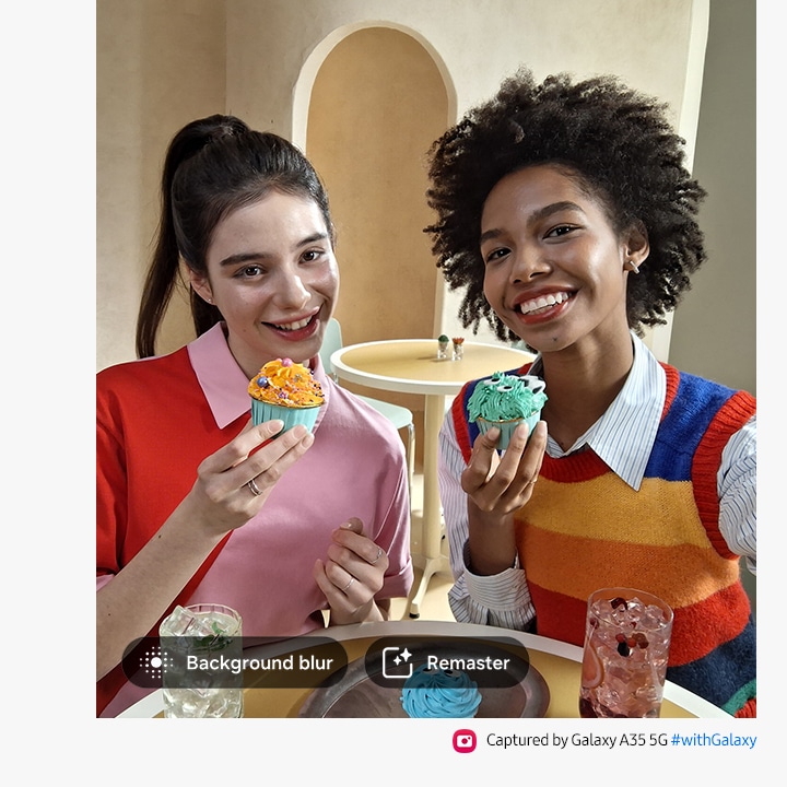 Deux personnes souriant et tenant des cupcakes. avec des options pour le flou d'arrière-plan, Remaster. Le texte indique Capturé par le Galaxy A35 5G #withGalaxy.