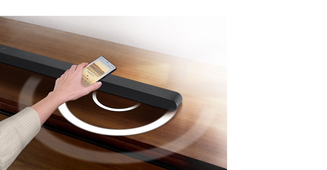 Una mano acerca el teléfono a la barra para activar Tap Sound