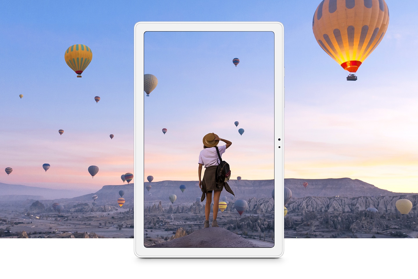 Galaxy Tab A7 depicts a woman overlooking a canyon filled with flying hot air balloons at dawn.