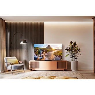 A Neo QLED TV is on display in a cozy bedroom-like environment. 