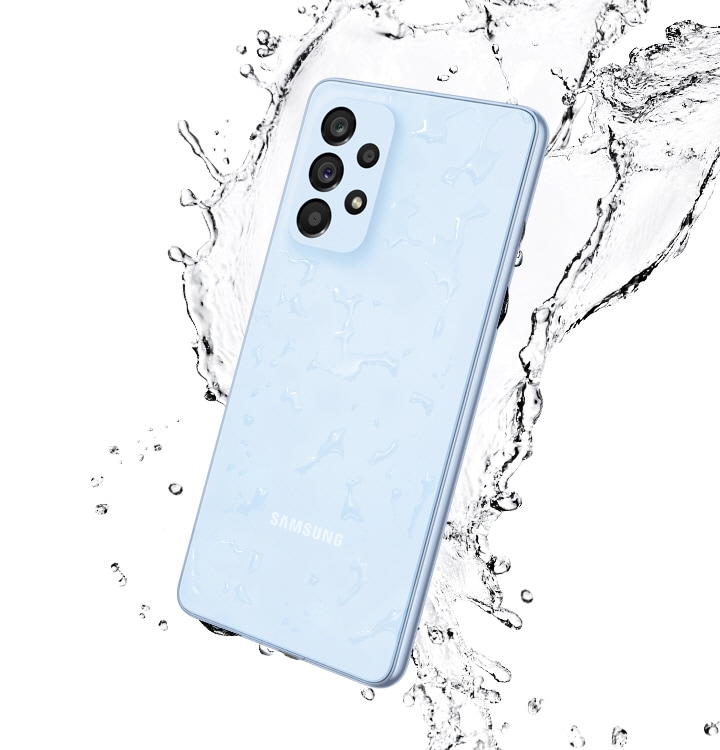Galaxy A53 5G in Awesome Blue, seen from the rear with water splashing around it