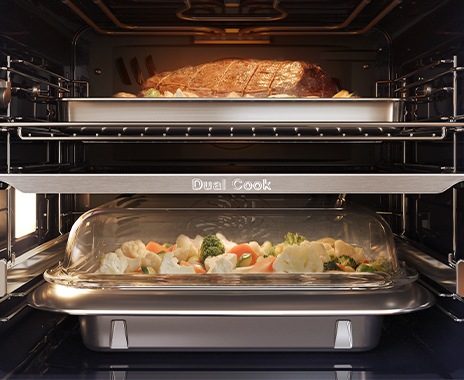 Shows the inside of the oven with a joint of meat roasting in the top zone and vegetables being steamed in the lower zone.