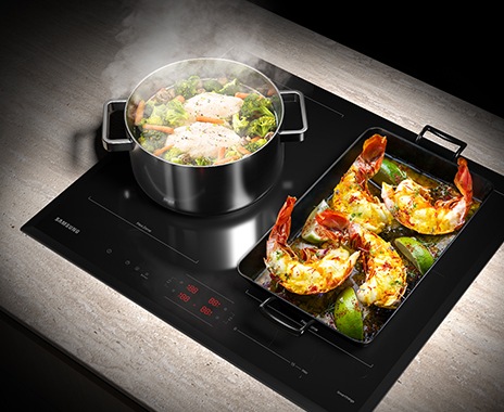 A round stockpot with a boiling chicken breast and vegetables is on the left Flex Zone, and the large square grill pan with lobster grilling is on the right Flex Zone.