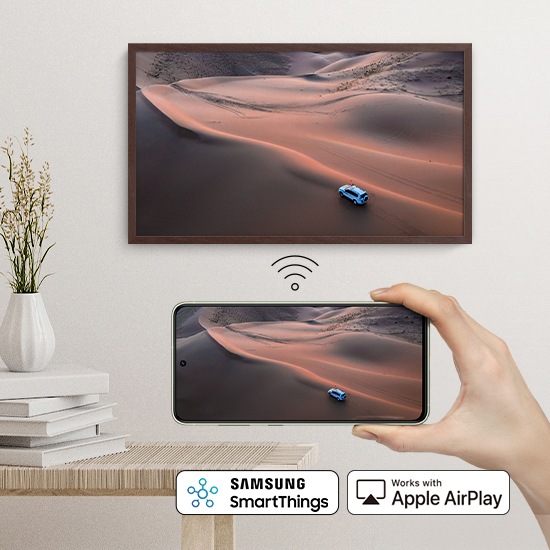 Một người đang cầm điện thoại thông minh đang phản chiếu cùng một nội dung trên The Frame.