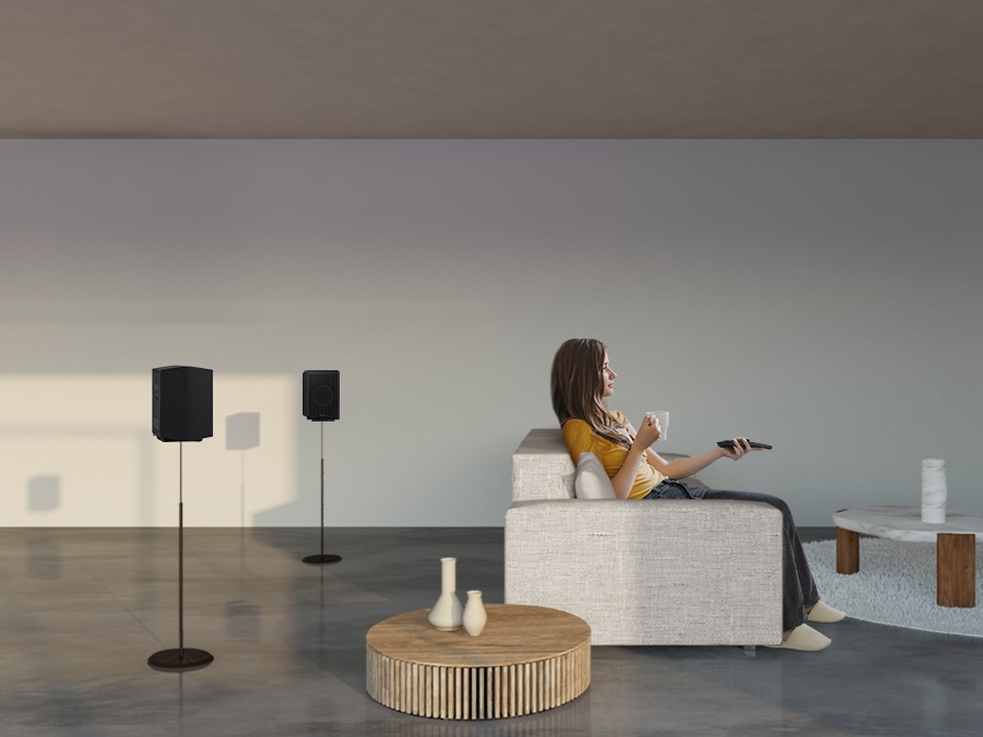 A woman enjoys TV. Soundwave graphics demonstrate Q930B wireless rear speaker's upfiring capability in addition to normal sound output direction when toggle is on.