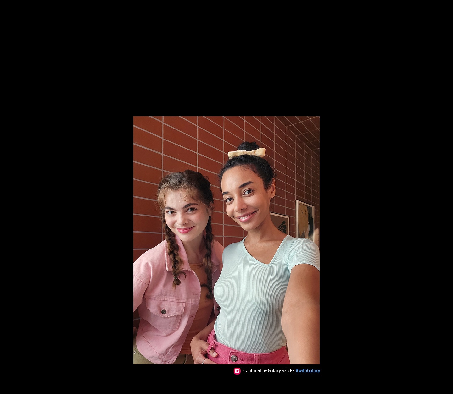 Dos mujeres se toman un selfie con el Galaxy S23 FE. La imagen tomada con su cámara frontal tiene colores vivos. El texto dice Capturada por Galaxy S23 FE #withGalaxy.