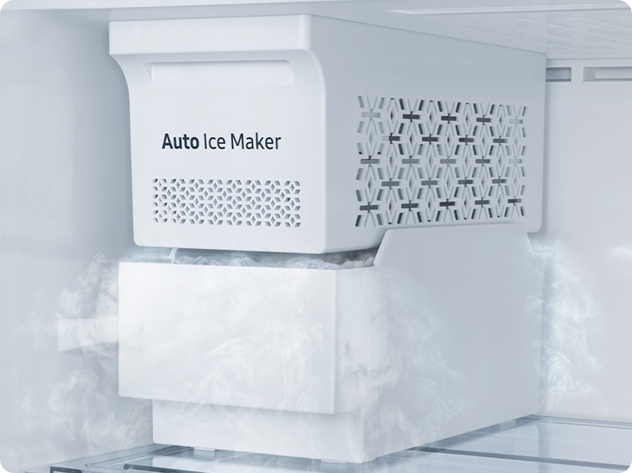 Primer plano de la máquina de hielo automática. Los cubitos de hielo están llenos en el contenedor de abajo y el aire frío fluye.