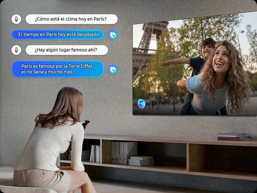 Una mujer en la sala habla con Bixby a través del televisor. Se muestran subtítulos. ¿Qué tiempo hace hoy en París? Hoy el tiempo está despejado en París. ¿Hay algún lugar famoso allí? París es famoso por la Torre Eiffel, el río Sena y mucho más.