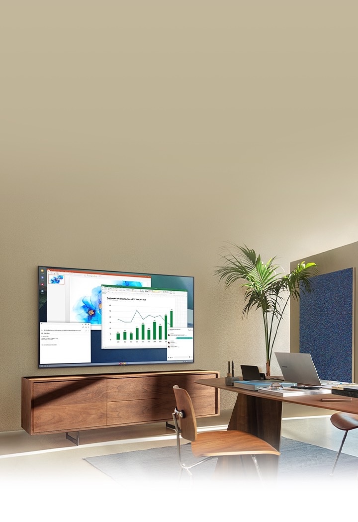 In a living room home office, A TV screen shows PC on TV feature which allows home TV to connect to office PC.