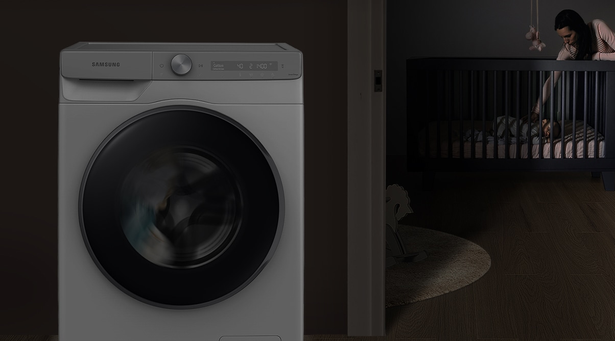 The mother puts the baby to sleep in the room at night, and the washer silently operates beside them.