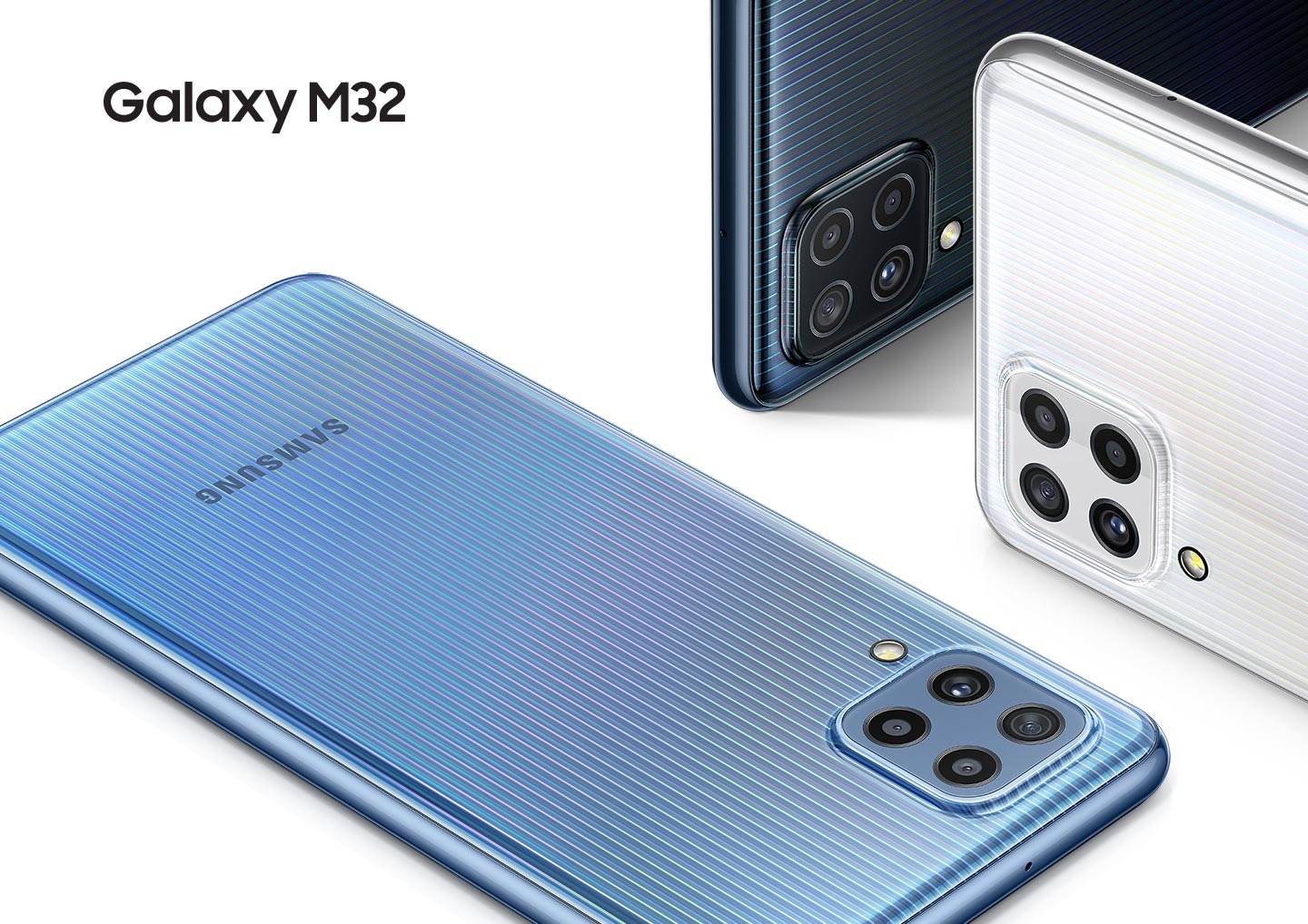 Three Galaxy M32 phones are displayed; sky blue one seen from the rear with the front screen facing down. The black and white ones are laying on the side with just a small part of the devices showing.