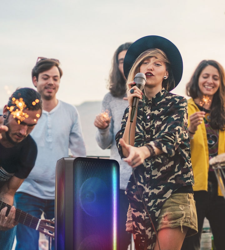 A woman is singing with the Sound Tower on Karake Mode with many people surrounding the singer.